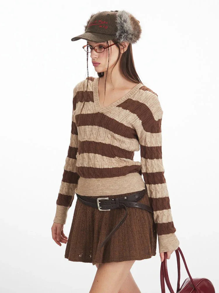 Close-up of a woman's upper body wearing a brown and beige striped knit hooded sweater with a v-neckline and long sleeves.