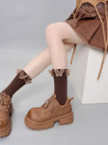 Model showcasing brown ribbed socks with butterfly accents and a ruffled edge, styled with brown platform shoes.