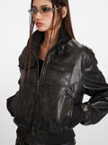 Woman wearing a black faux leather bomber jacket with a stand collar and ribbed cuffs.