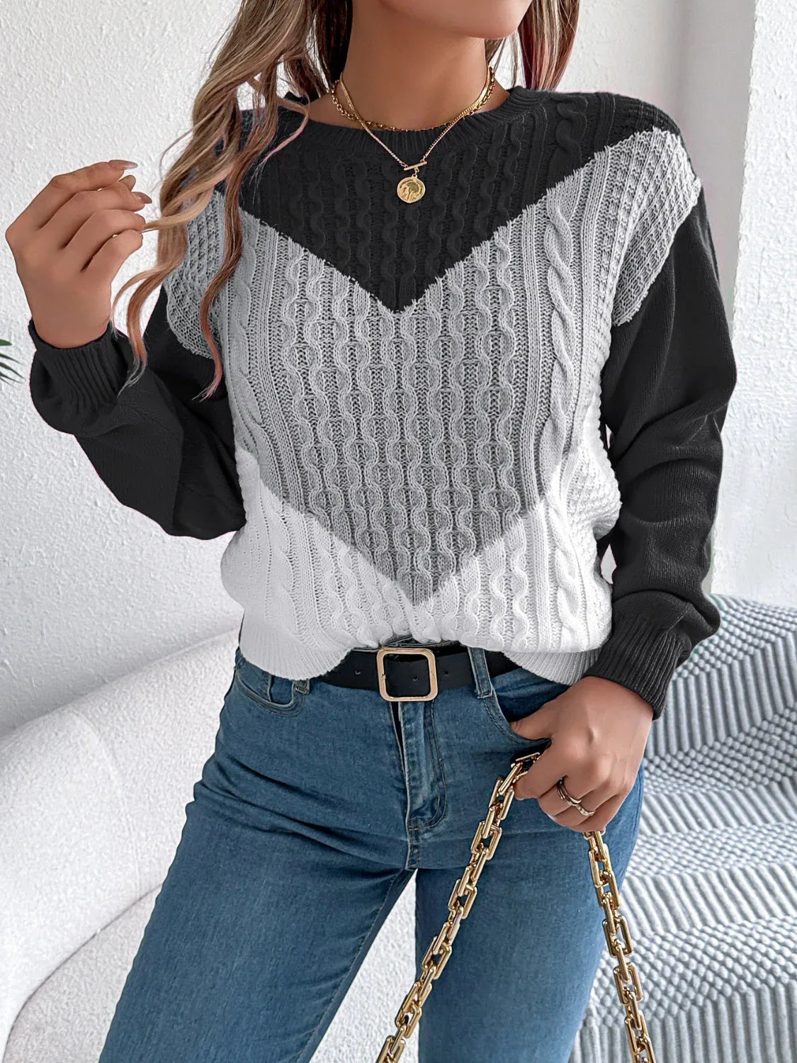 Model showcasing the fit of a women's long sleeve knit sweater.