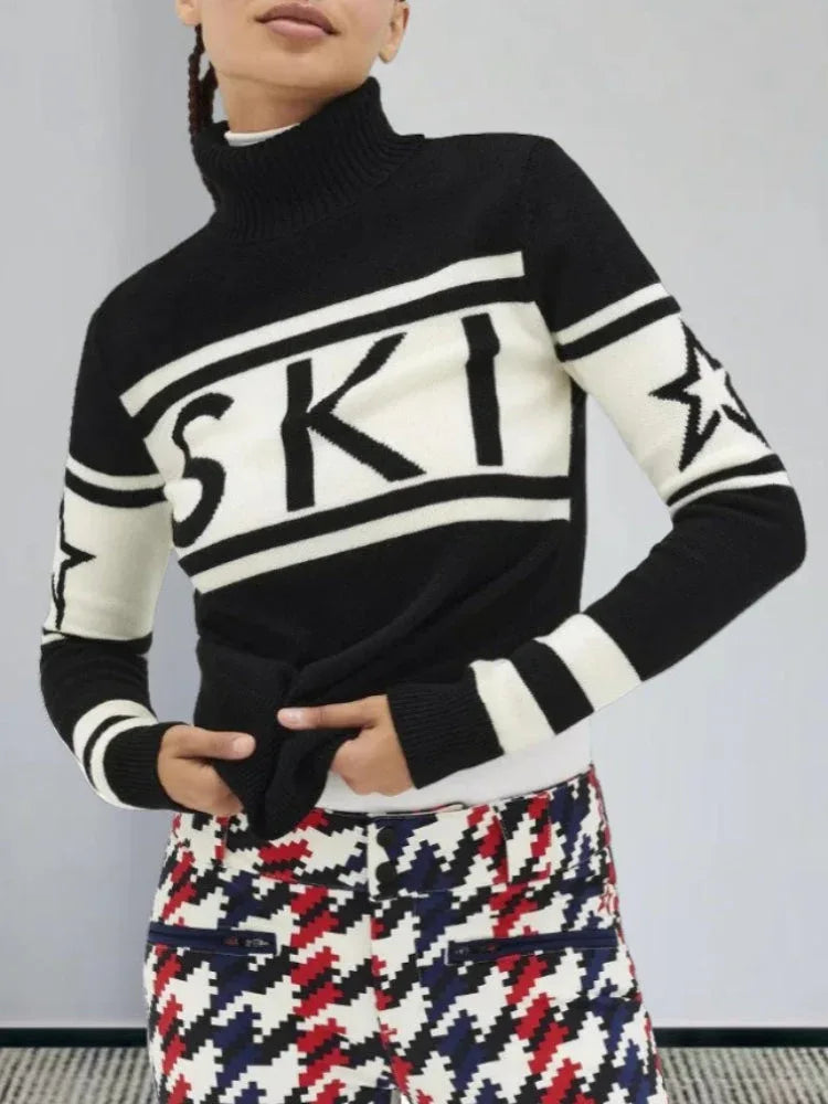 Close-up of a woman wearing a black and white knit turtleneck sweater with 'SKI' graphic
