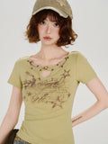 Detail shot of the t-shirt's graphic print and the cut-out neckline with star embellishments.