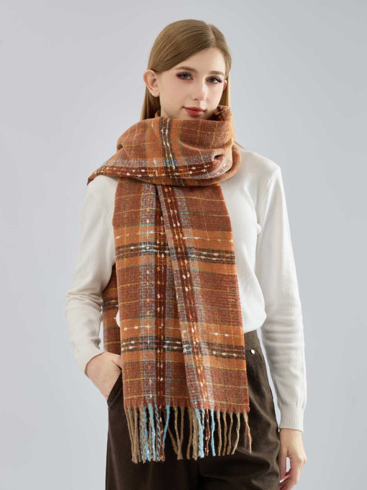 Woman wearing an orange tartan plaid scarf with fringe