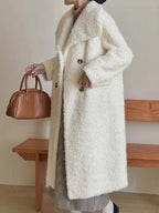 Side view of a woman in a long white textured fleece coat with an oversized collar.