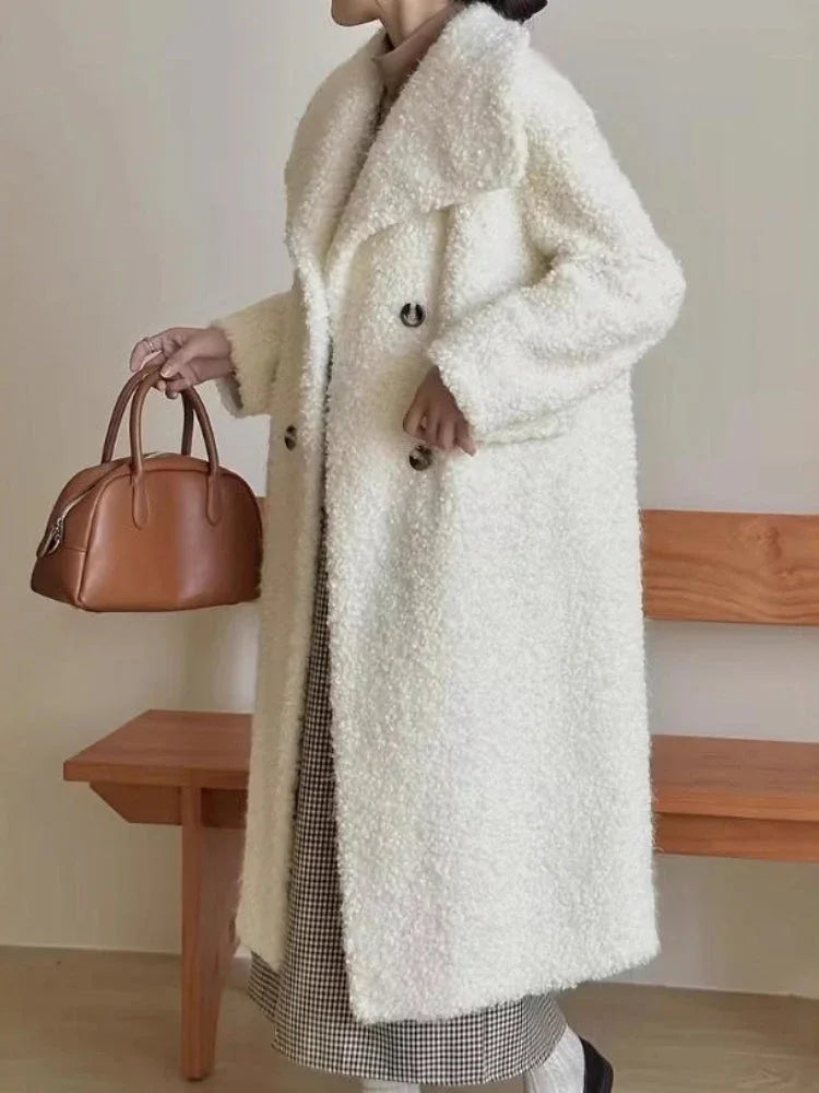 Side view of a woman in a long white textured fleece coat with an oversized collar.