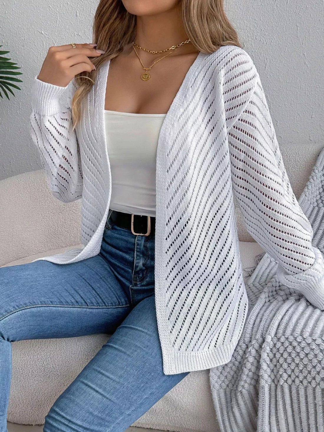 Woman wearing a white open-front pointelle knit cardigan