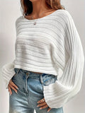 Woman wearing a white cropped bell sleeve sweater with blue jeans