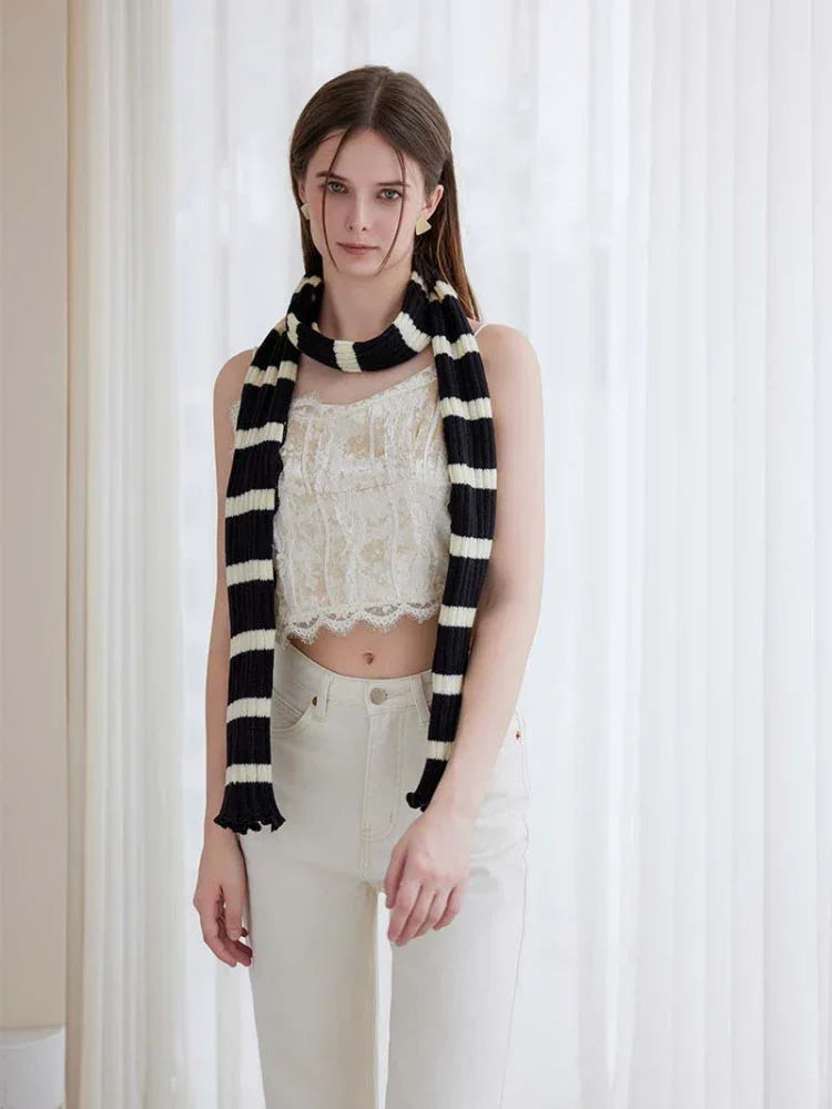 Woman wearing a long black and white striped knit scarf with ruffle edges - View 6 | WEUXS