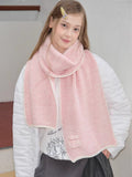 Model wearing a pink ribbed knit scarf with white trim