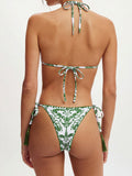 Front view of a white and green patterned bikini set with tassel details on the bottoms