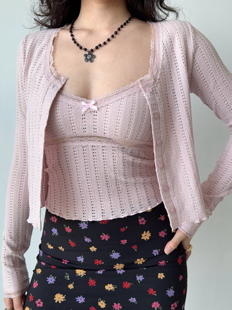 Model showcasing a pink knit cardigan with a cropped silhouette and long sleeves.