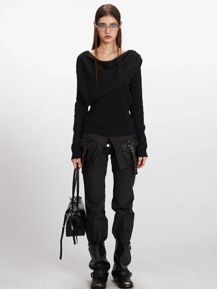 Woman wearing a black long-sleeve asymmetrical knit sweater and black pants