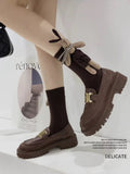 Full view of brown crew socks with a 3D bunny embellishment and striped scarf detail.