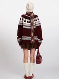 Back view of a woman in a burgundy Fair Isle sweater with apple pattern and white knit hat