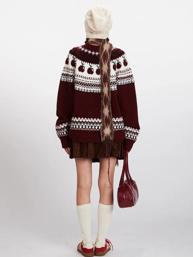 Back view of a woman in a burgundy Fair Isle sweater with apple pattern and white knit hat