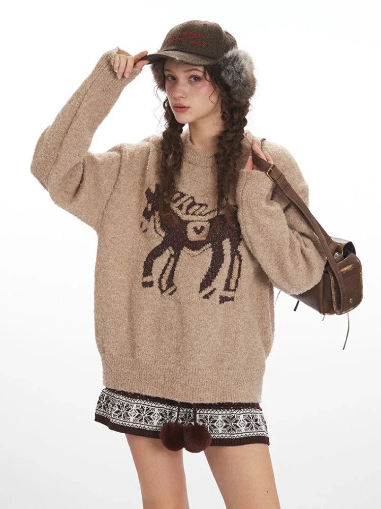 Close-up of a woman wearing a tan knit sweater with a brown intarsia horse graphic.