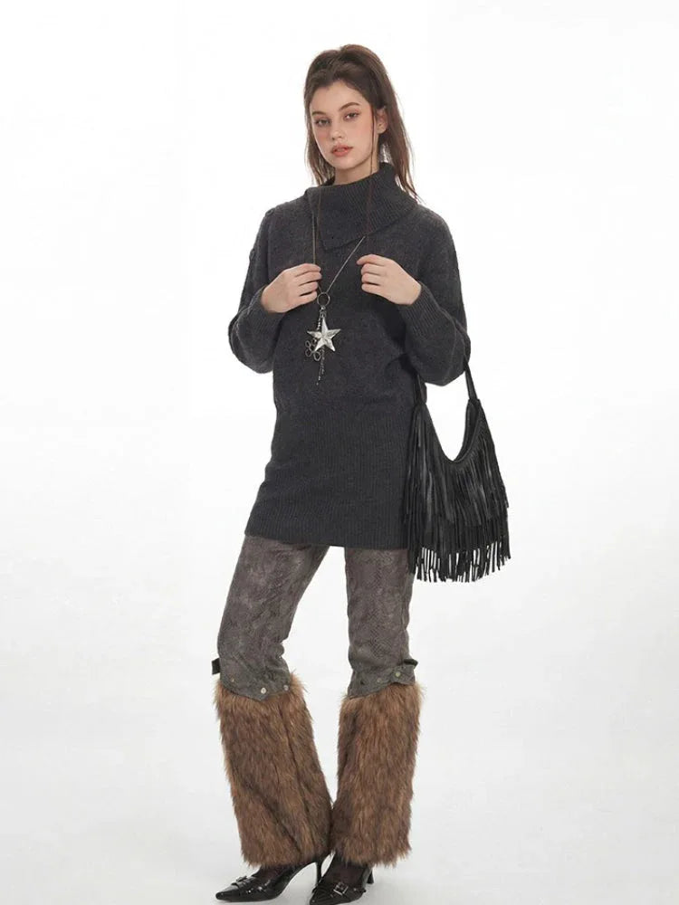 Model posing with a black fringe handbag while wearing a charcoal grey knit tunic sweater.