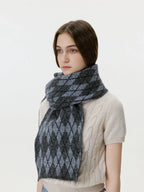 Close-up of a woman wearing a gray and black argyle knit scarf