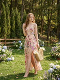 Woman in a cream floral print maxi dress with a high slit standing in a garden.