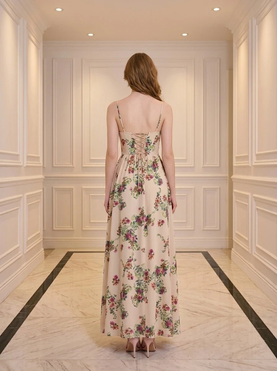 Woman wearing a cream floral print maxi dress with spaghetti straps and a high slit.