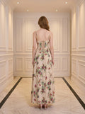 Back view of a woman in a cream floral print maxi dress with a lace-up back.