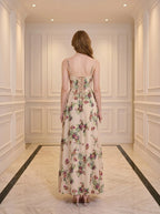 Back view of a woman in a cream floral print maxi dress with a lace-up back.