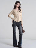 Front view of a grey ribbed knit cropped tank top with lace trim and a bow, paired with dark trousers.