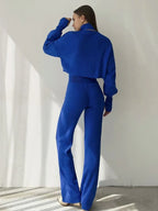Back view of a woman in a royal blue knit set, showing the relaxed fit of the top and the straight leg of the pants.
