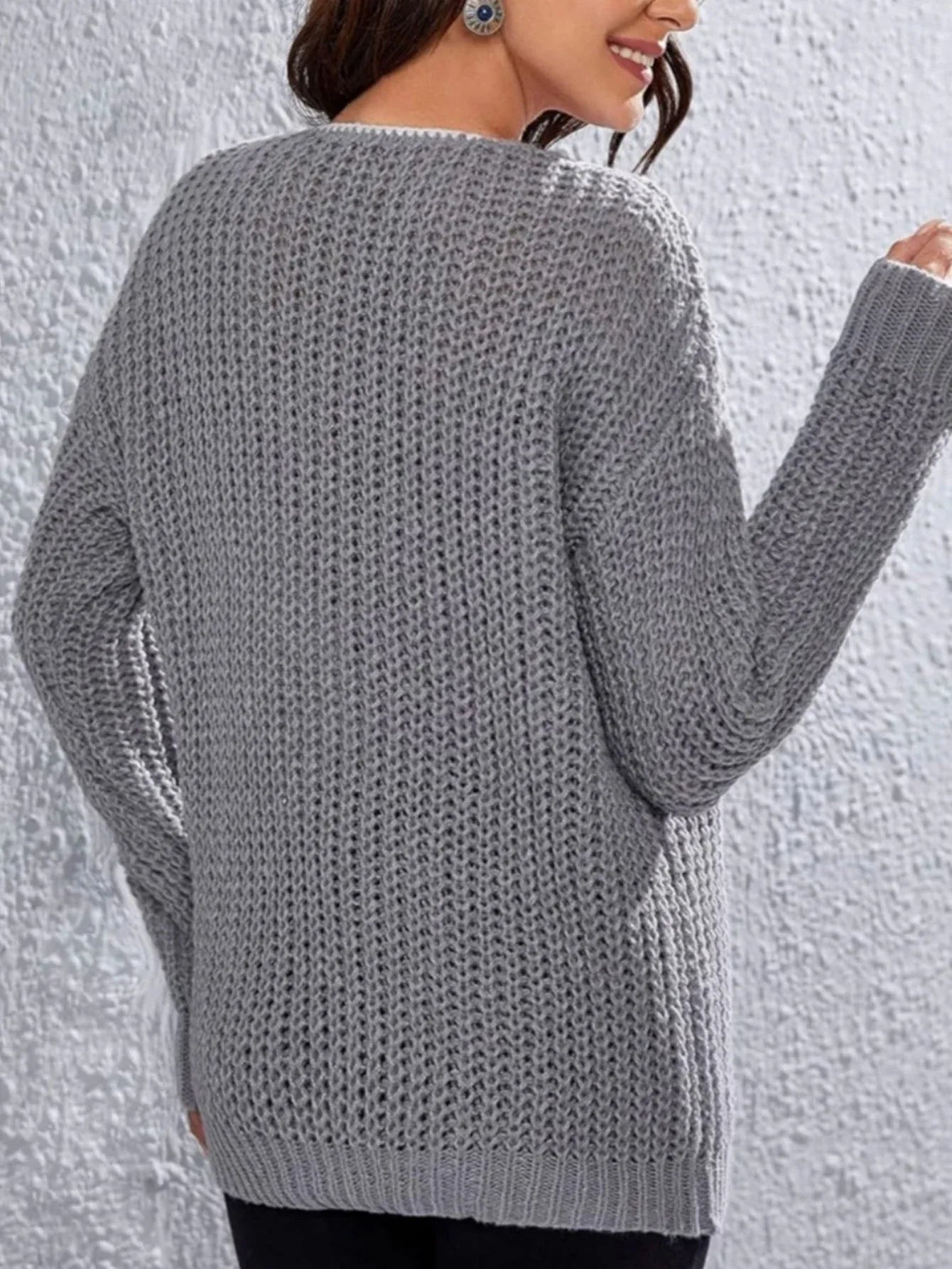 Back view of a woman in a grey textured knit sweater.