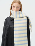 Portrait of a woman with a cream and light blue striped scarf wrapped around her neck.