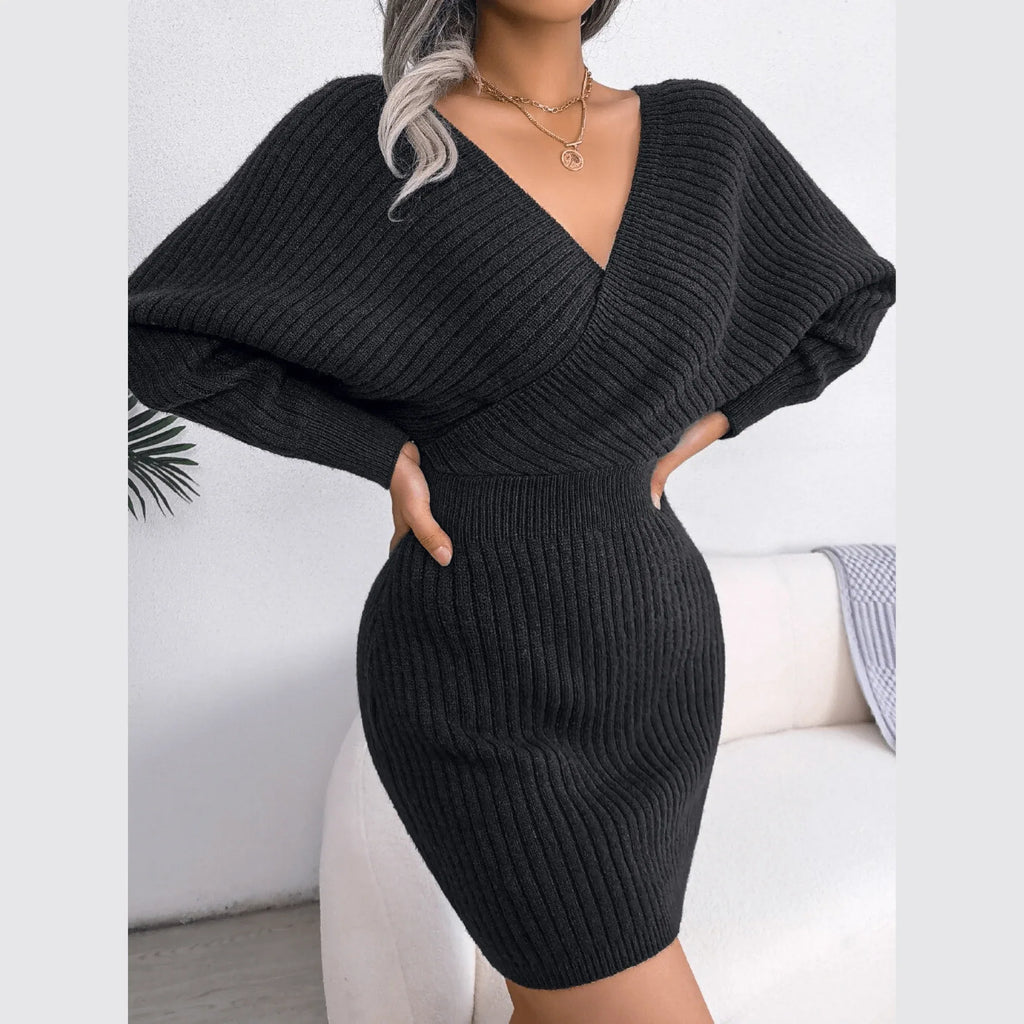 Model posing in a charcoal grey knit wrap dress