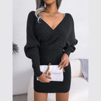Woman holding a white quilted handbag wearing a charcoal grey long-sleeved V-neck wrap knit dress.