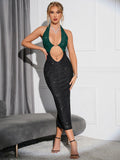 Full-length view of a woman wearing a sparkling green and black halter neck midi dress
