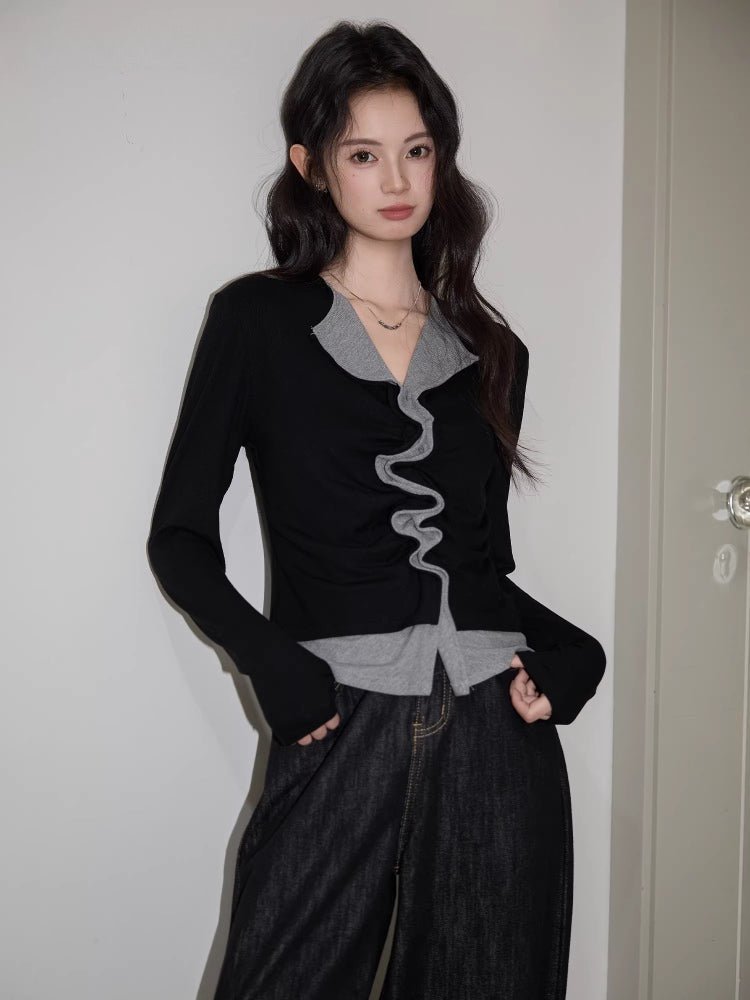 Front view of a woman in a black and grey layered top with ruched detailing.