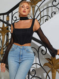 Close-up of a woman in a black crop top with mesh sleeves and a choker.