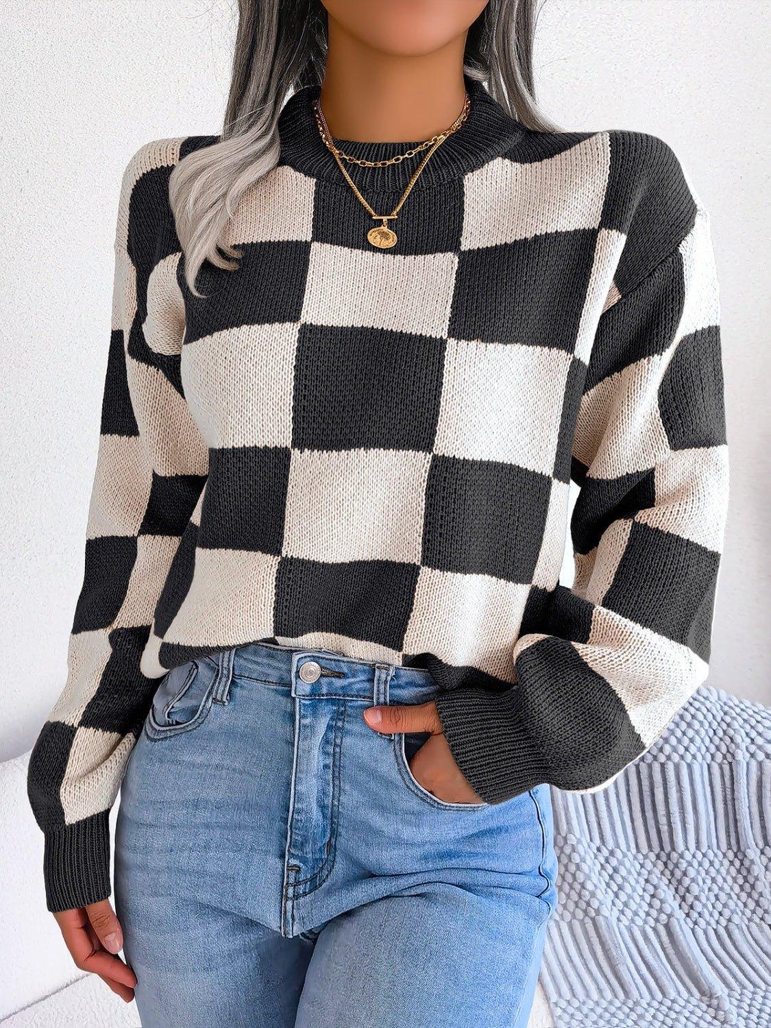 Woman wearing a black and cream checkerboard knit sweater with blue jeans. Main image