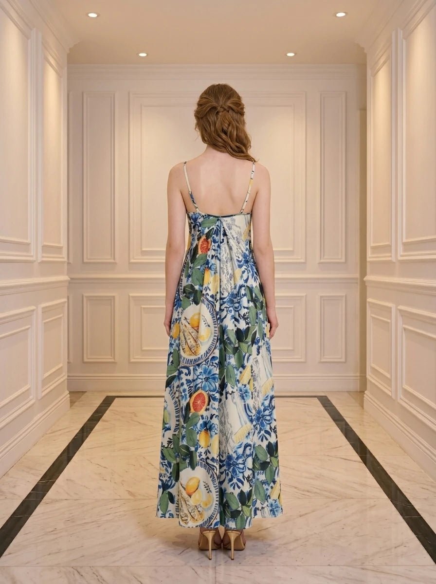 Back view of a woman in a maxi dress with a fruit and floral print.