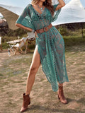 Woman wearing a green lace maxi beach cover up outdoors