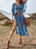 Woman wearing a blue lace maxi beach cover up with a bag