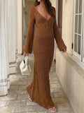 Woman wearing a brown open-knit maxi dress with bell sleeves and a plunging V-neckline.