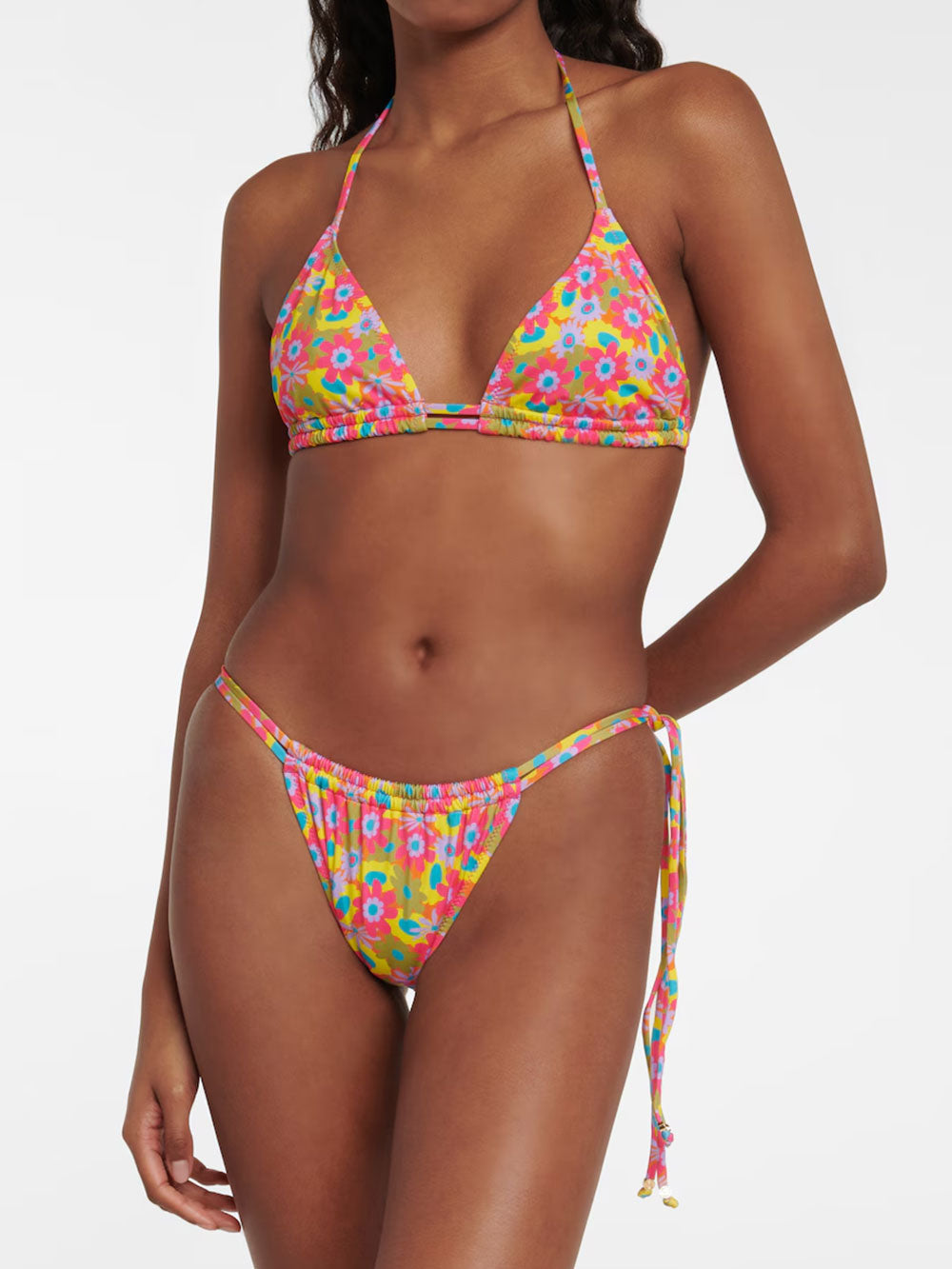 Woman wearing a pink, yellow, and blue floral print triangle bikini top with adjustable halter ties