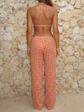 Woman wearing a patterned bikini top and matching wide-leg pants, back view