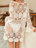 Woman wearing a black crochet knit beach cover-up with lace-up neckline and bell sleeves
