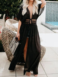 Woman wearing a black maxi beach cover-up with lace waist detail and deep V-neck