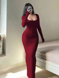 Woman in a long-sleeved, form-fitting, scoop neck red maxi dress.