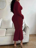 Rear view of a woman in a long-sleeved, form-fitting, scoop neck red maxi dress.