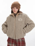Front view of a model wearing a tan fleece bomber jacket with hands in pockets.