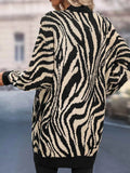 Back view of a woman in a black and white zebra print knit cardigan.