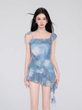 Woman wearing a blue tie-dye print mini dress with ruffle trim and tie shoulder straps