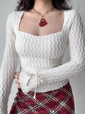 White textured long sleeve top with square neckline and tie cuffs.